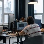 Equipe de desenvolvedores trabalha em computadores em um escritório moderno de tecnologia