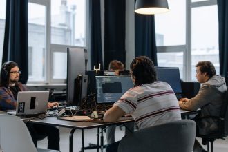 Equipe de desenvolvedores trabalha em computadores em um escritório moderno de tecnologia