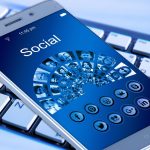 Cartão de benefício social ao lado de um smartphone sobre uma mesa de madeira.