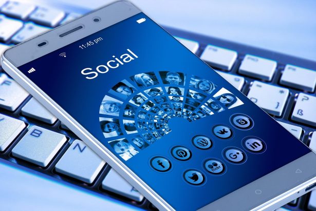 Cartão de benefício social ao lado de um smartphone sobre uma mesa de madeira.